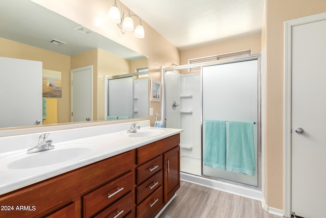 bathroom featuring vanity, a shower with shower door, and hardwood / wood-style floors