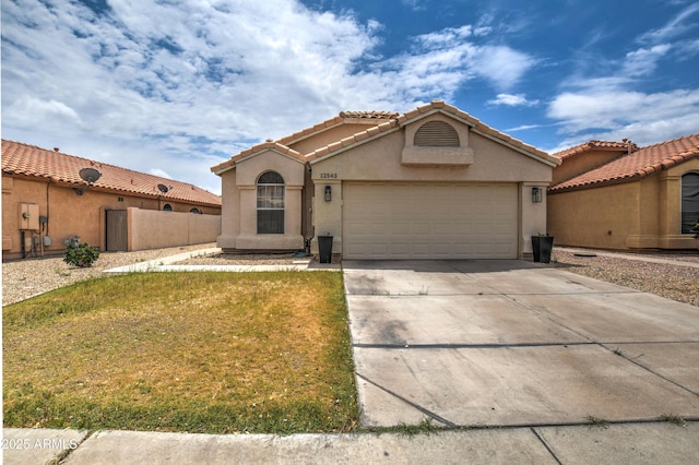 12543 W Roanoke Ave, Avondale, AZ 85392 - view of front of house with fence, an attached garage, concrete driveway, stucco siding, and a tiled roof