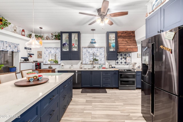 kitchen featuring appliances with stainless steel finishes, light countertops, and blue cabinets