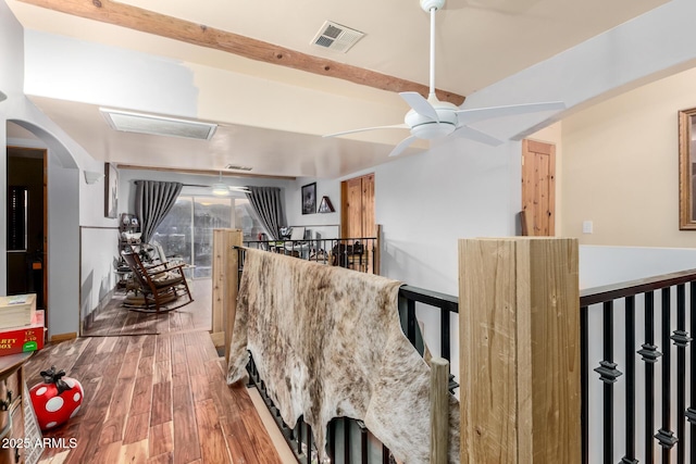 dining room featuring a ceiling fan, visible vents, arched walkways, and wood finished floors