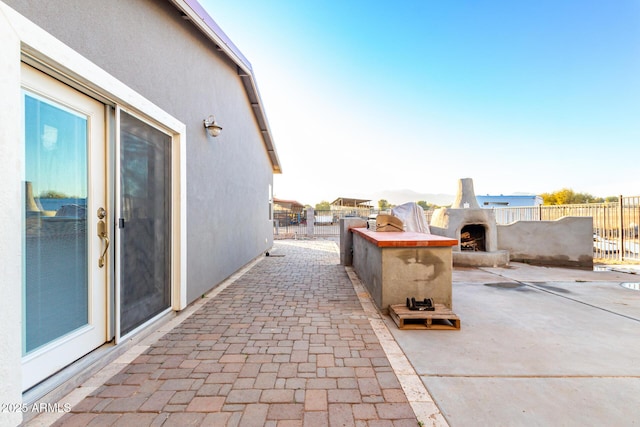 view of patio / terrace with fence and an outdoor fireplace