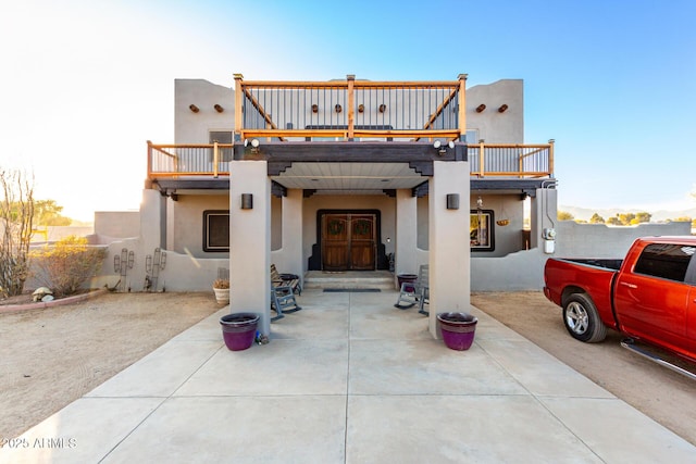 rear view of property with a patio and stucco siding