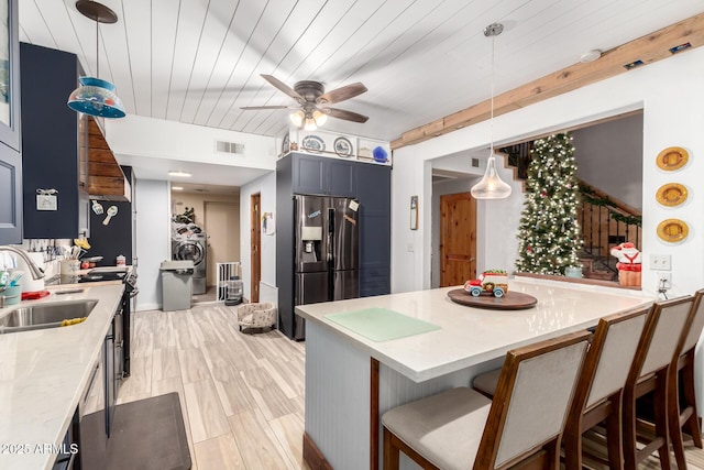 kitchen with visible vents, wood ceiling, a breakfast bar, refrigerator with ice dispenser, and a sink