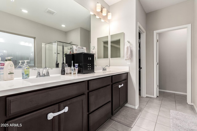 bathroom featuring walk in shower, vanity, and tile patterned flooring