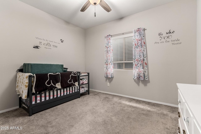 carpeted bedroom with a nursery area and ceiling fan