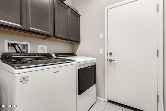 clothes washing area featuring light tile patterned floors, cabinets, and washing machine and clothes dryer