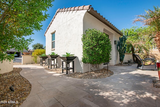 view of side of home with a patio area