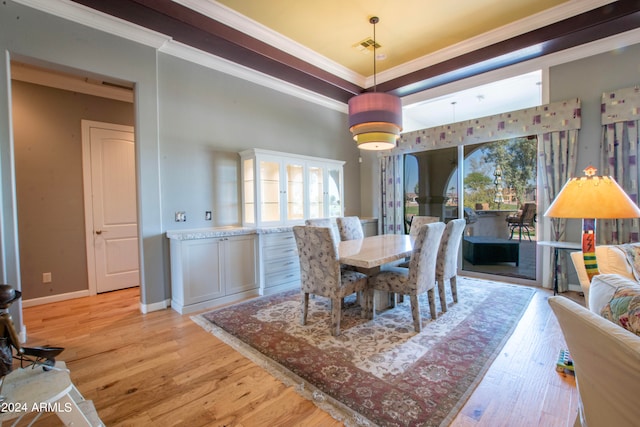 dining area featuring a healthy amount of sunlight, ornamental molding, and light wood-type flooring