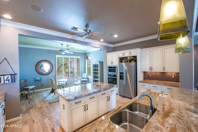 kitchen with sink, light wood-type flooring, high quality fridge, white cabinets, and light stone counters