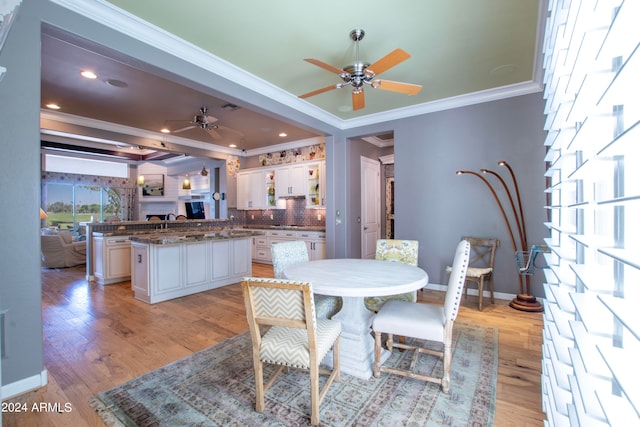 dining area with light hardwood / wood-style floors, crown molding, and ceiling fan