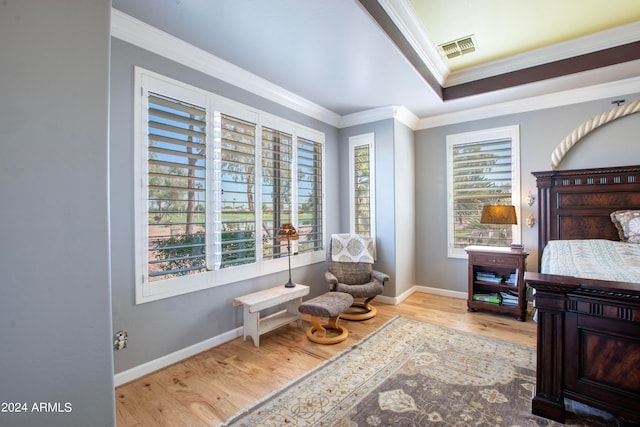 living area with ornamental molding, plenty of natural light, and light wood-type flooring