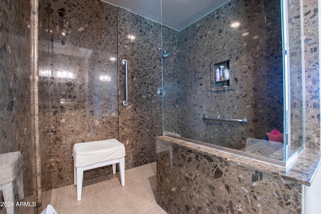 bathroom with tiled shower and a textured ceiling