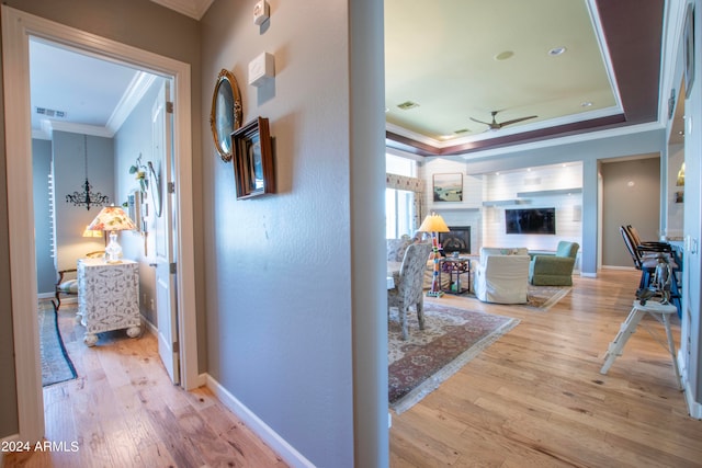 corridor featuring ornamental molding and light hardwood / wood-style flooring