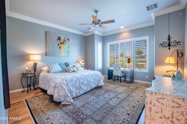 bedroom featuring ornamental molding, wood-type flooring, and ceiling fan