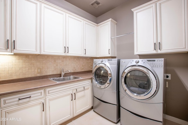 washroom featuring cabinets, sink, and separate washer and dryer