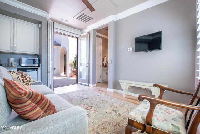 living room featuring ornamental molding and light hardwood / wood-style flooring