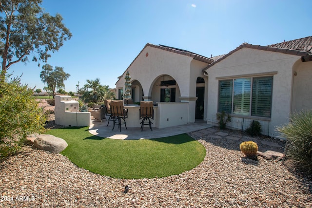 back of property featuring a patio area and an outdoor bar