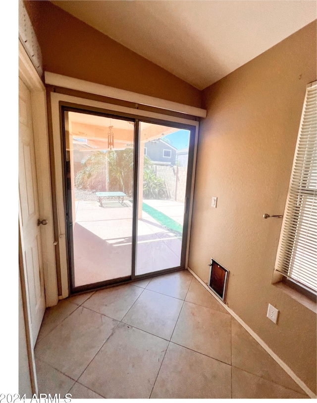 entryway featuring vaulted ceiling and tile patterned flooring