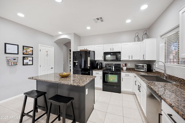 4466 S Brice, Mesa, AZ 85212 - kitchen with black appliances, a sink, a breakfast bar area, a kitchen island, and dark stone counters
