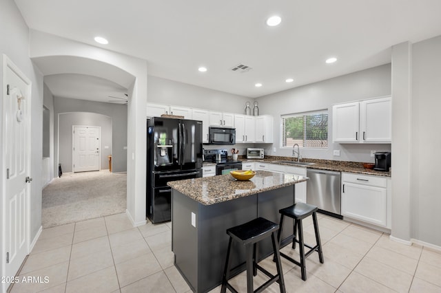 4466 S Brice, Mesa, AZ 85212 - kitchen with black appliances, a sink, a center island, arched walkways, and dark stone countertops