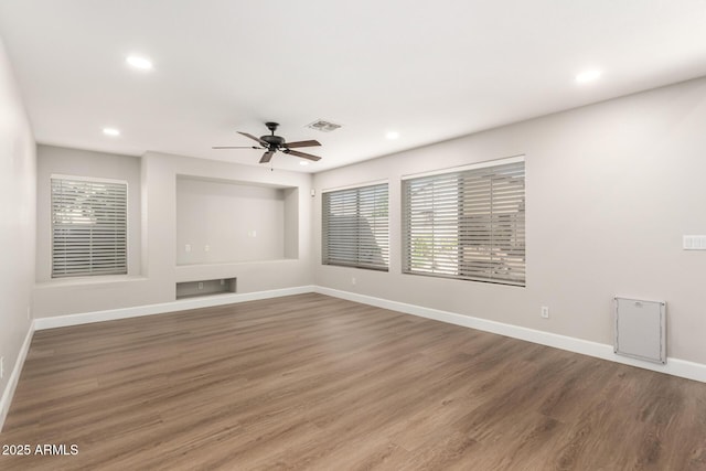 unfurnished living room with recessed lighting, visible vents, baseboards, and wood finished floors