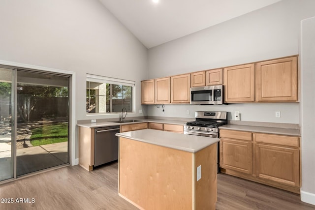 kitchen featuring stainless steel appliances, light countertops, light wood-style flooring, light brown cabinets, and a sink