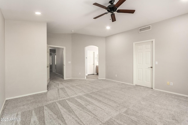 unfurnished room featuring arched walkways, recessed lighting, light colored carpet, visible vents, and baseboards