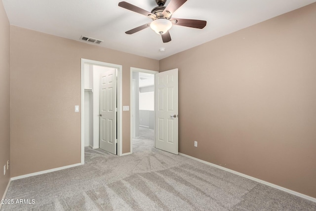 unfurnished bedroom featuring baseboards, a ceiling fan, visible vents, and light colored carpet