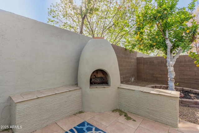 view of patio featuring fence private yard and exterior fireplace