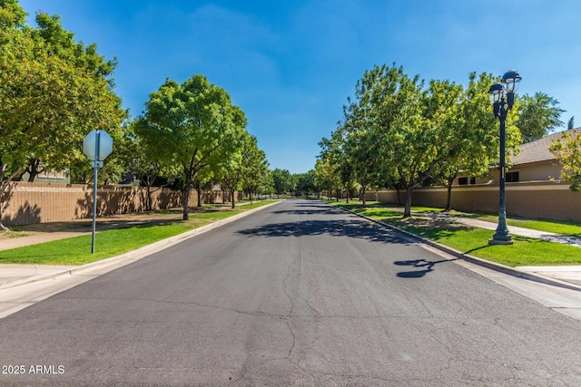 view of street featuring sidewalks, traffic signs, curbs, and street lights