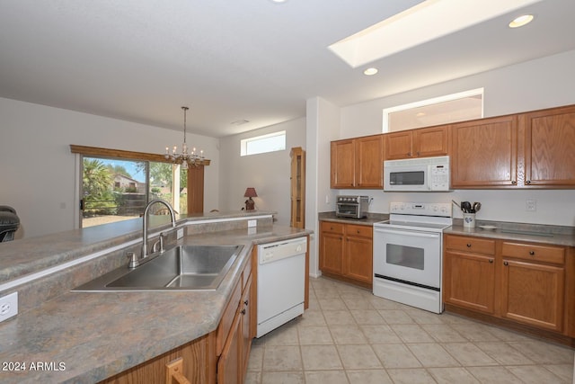 kitchen with sink, decorative light fixtures, white appliances, and a notable chandelier