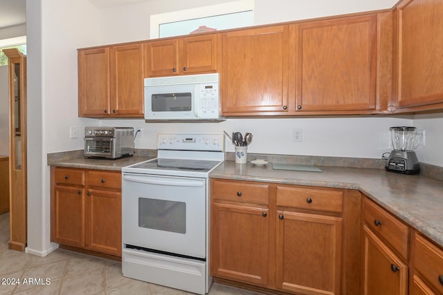 kitchen featuring light tile patterned floors and white appliances