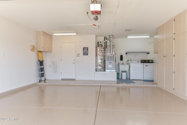 garage with a garage door opener, washer and dryer, heating unit, and water heater