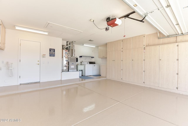 garage with independent washer and dryer, a garage door opener, sink, and water heater