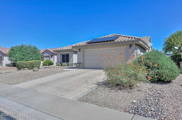 view of front of house featuring a garage and solar panels