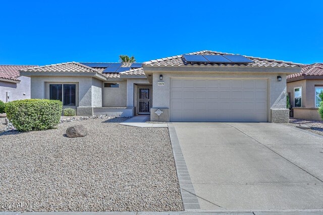 view of front of home featuring a garage and solar panels