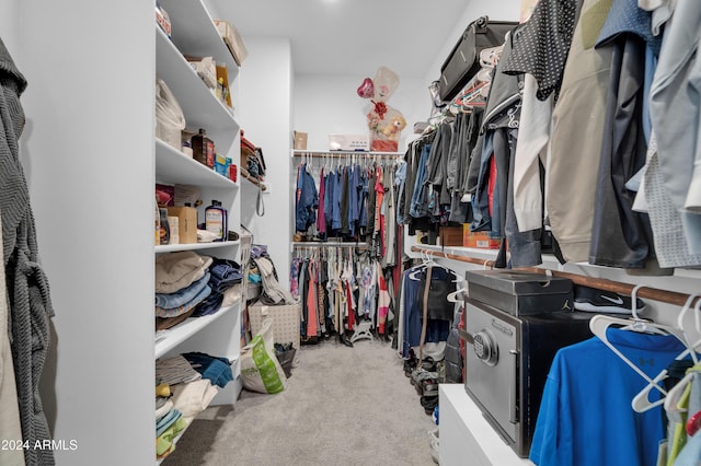 walk in closet featuring light colored carpet