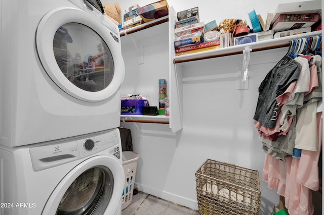 clothes washing area featuring stacked washer and clothes dryer