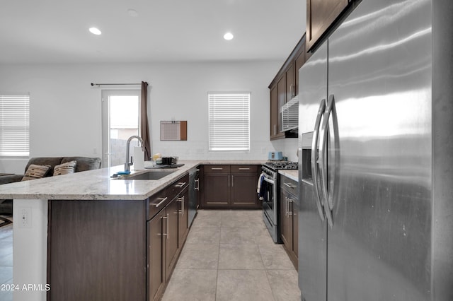 kitchen featuring sink, tasteful backsplash, kitchen peninsula, light tile patterned flooring, and appliances with stainless steel finishes