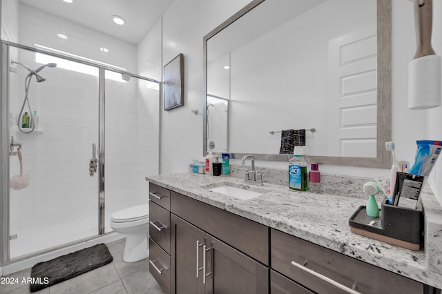 bathroom with tile patterned flooring, vanity, toilet, and walk in shower