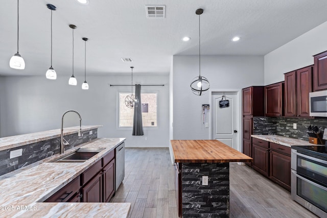 7911 E Posada Ave, Mesa, AZ 85212 - kitchen with stainless steel appliances, backsplash, pendant lighting, light wood-style flooring, and recessed lighting
