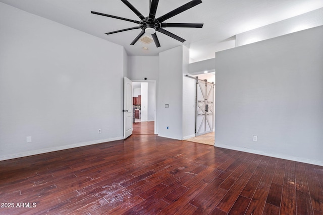 7911 E Posada Ave, Mesa, AZ 85212 - spare room featuring a barn door, wood finished floors, ceiling fan, and a towering ceiling