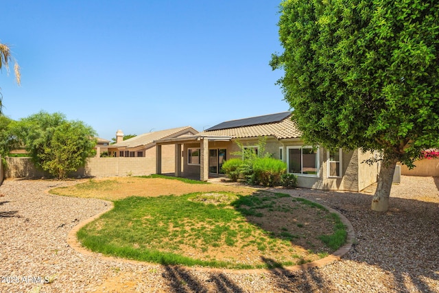 7911 E Posada Ave, Mesa, AZ 85212 - rear view of house featuring roof mounted solar panels, a fenced backyard, stucco siding, and a tile roof