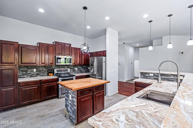 7911 E Posada Ave, Mesa, AZ 85212 - kitchen featuring stainless steel appliances, wooden counters, dark brown cabinets, backsplash, and a kitchen island