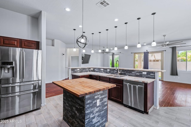 7911 E Posada Ave, Mesa, AZ 85212 - kitchen with stainless steel appliances, a large island with sink, light wood-type flooring, ceiling fan, and recessed lighting