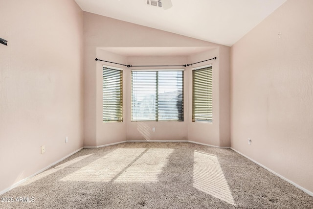 carpeted spare room featuring vaulted ceiling