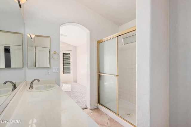 bathroom featuring tile patterned flooring, vanity, a shower with door, and lofted ceiling