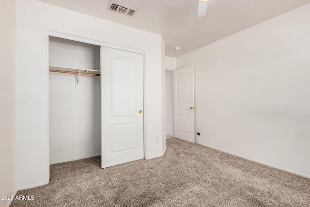 unfurnished bedroom featuring light carpet, a closet, and ceiling fan