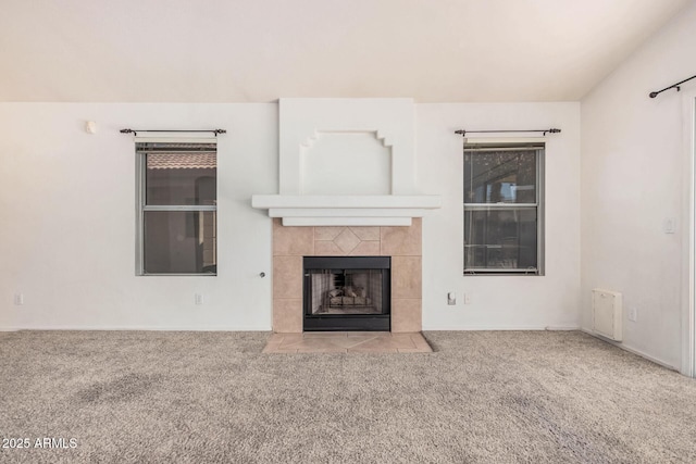 unfurnished living room featuring light carpet and a tile fireplace