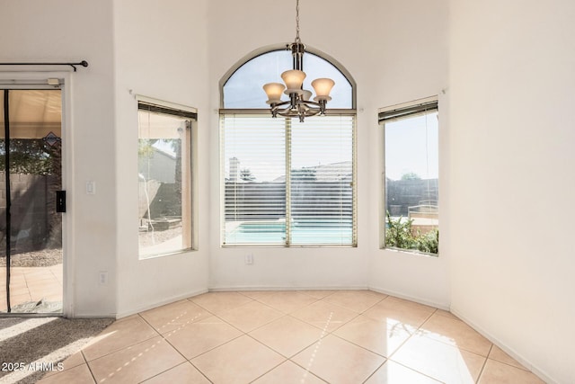 unfurnished dining area featuring plenty of natural light, light tile patterned floors, and a notable chandelier